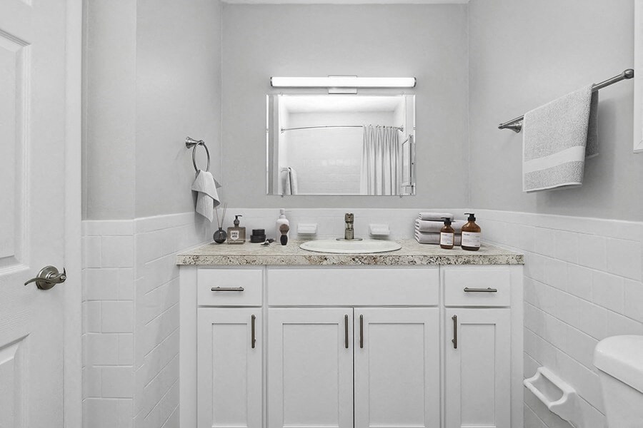Model Bathroom with White Cabinets and Wood-Style Flooring at Stone Ends Apartments in Stoughton, MA.