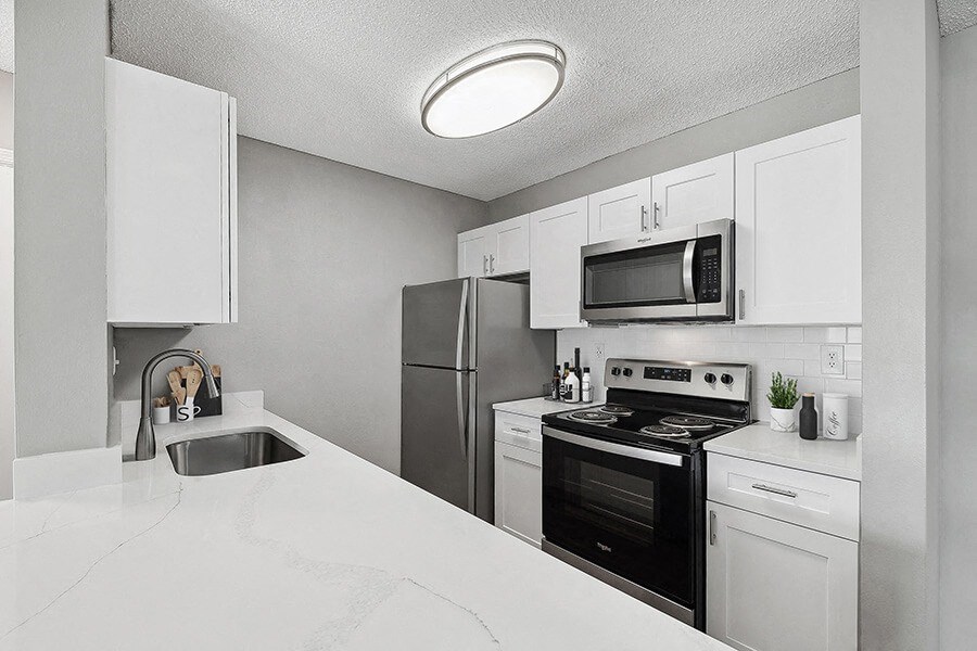 Model Kitchen with White Cabinets and White Marble Countertops at Fountains Lee Vista Apartments in Orlando, FL.