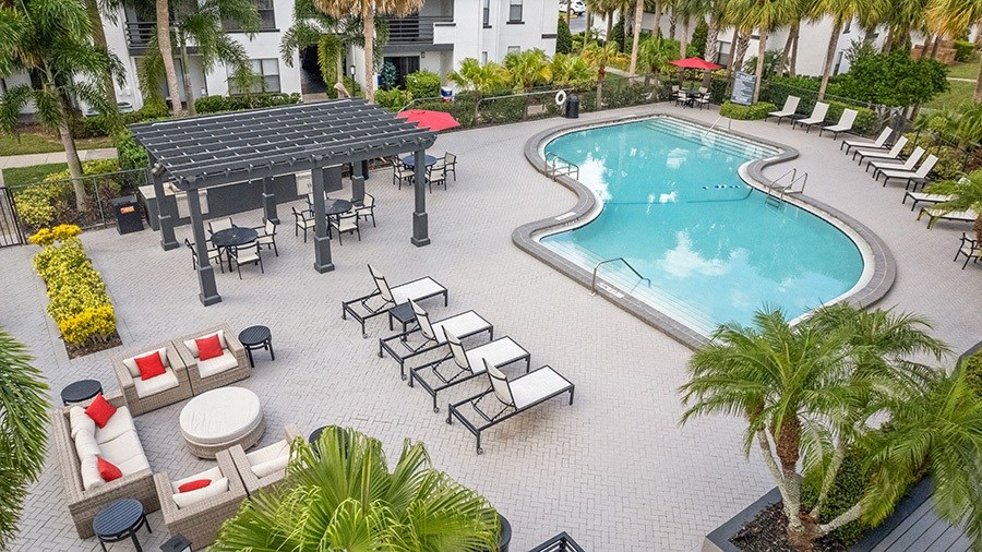 Aerial View of Community Swimming Pool and Pool Furniture at Rosehill Preserve Apartments in Orlando, FL.