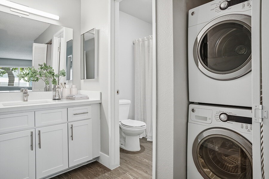 Model Bathroom with White Cabinets and Wood-Style Flooring at Cove La Mesa Apartments located in La Mesa, CA.