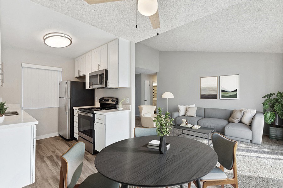 Model Dining Room and Kitchen with White Cabinets and Wood-Style Flooring at Bridges on Sunset Apartments in Suisun City, CA.