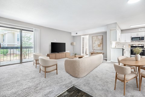 A living room with a grey carpet and wooden furniture.