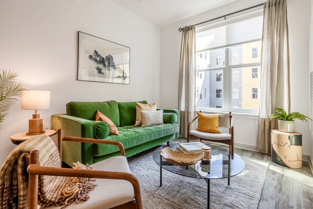 Model living room with a green couch and a window