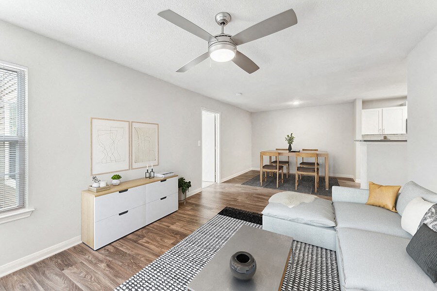 Model Living Room with Wood-Style Flooring and View of Dining Room at Lake Cameron Apartments located in Apex, NC.