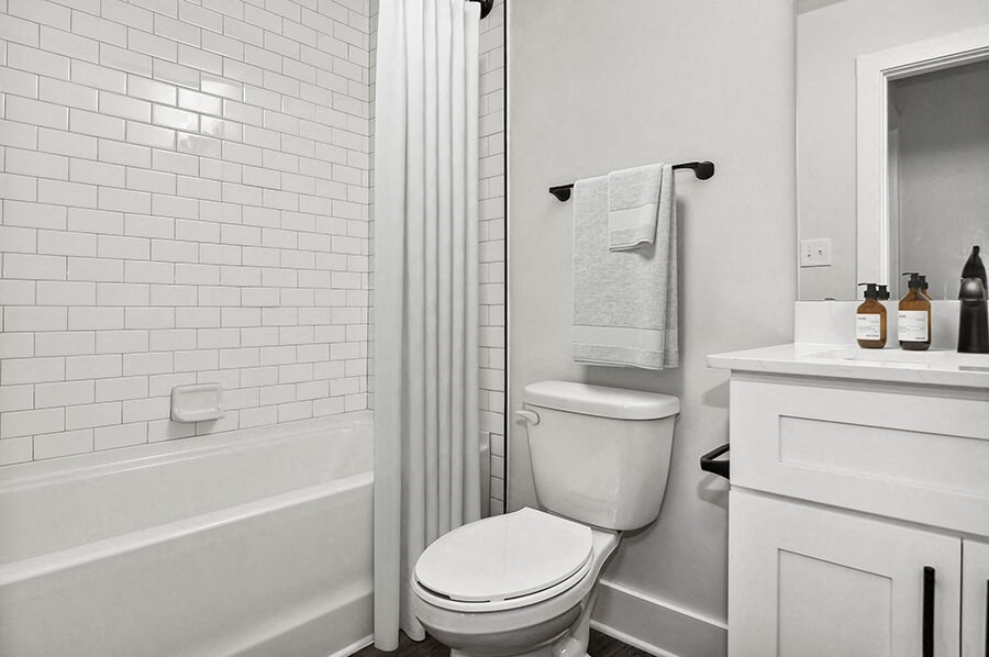 Model Bathroom with White Cabinets and Wood-Style Flooring at Park at Caterina Apartments located in Charlotte, NC.