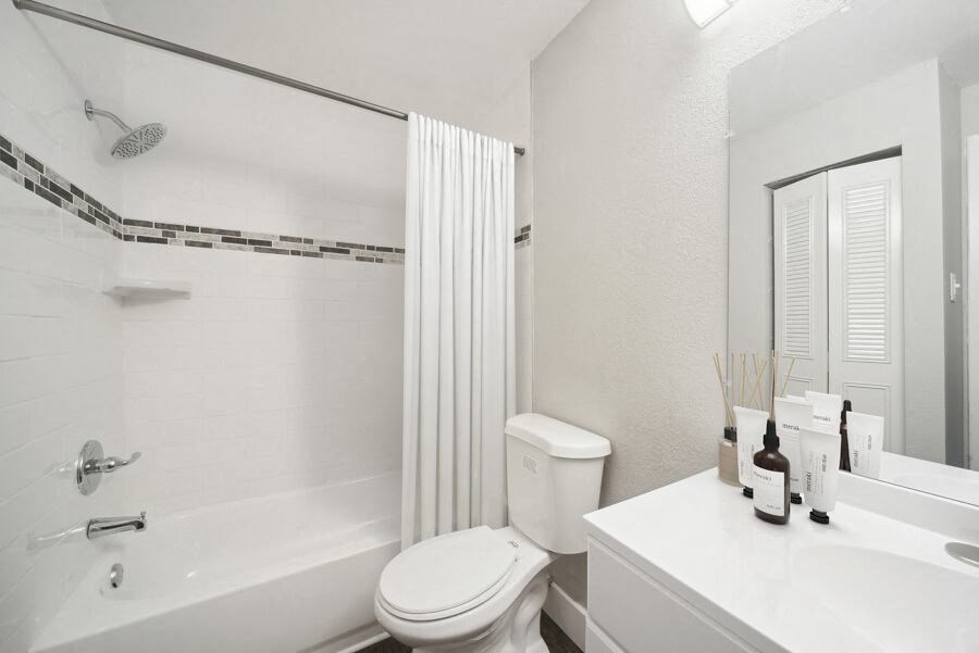 a bathroom with a white toilet sitting next to a bath tub