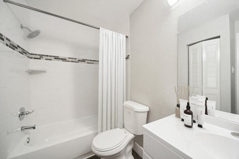 a bathroom with a white toilet sitting next to a bath tub