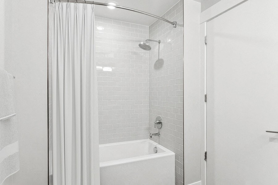 Model Bathroom with Wood-Style Flooring and Shower/Tub at Seven Skies Apartments located in Sandy, UT.