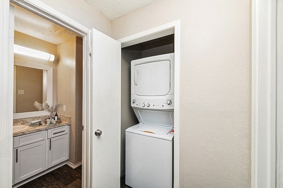Model Washer and Dryer Hook Up Area and View of Bathroom at Dallas North Park Apartments in Dallas, TX.
