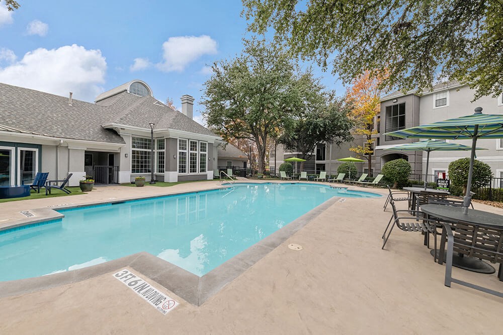 Community Swimming Pool with Pool Furniture at Bridges at Oakbend Apartments in Lewisville, TX.