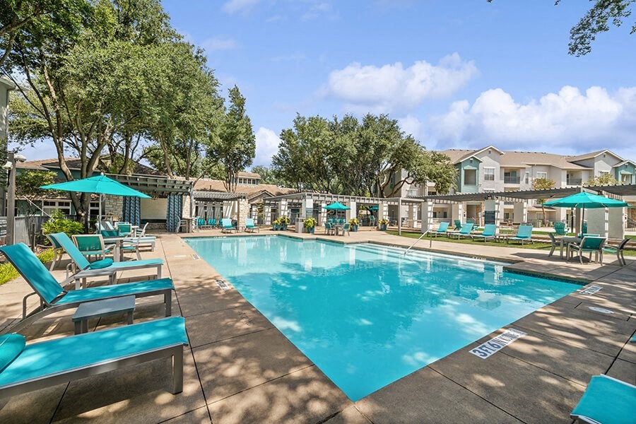 Community Swimming Pool with Pool Furniture at Essence Apartments in Dallas, TX.