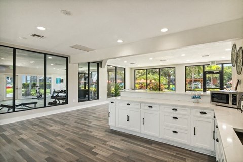 the kitchen has a large island with a microwave and windows