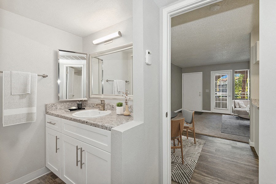Model Bathroom with White Cabinets and Wood-Style Flooring at Stillwater Apartments in Glendale, AZ.