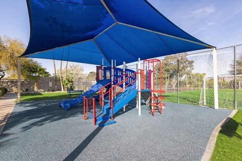 Community Playground with slide and blue canopy at Lakeside Casitas in Tucson, AZ.