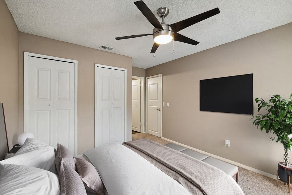 Model bedroom with a bed and a ceiling fan at Vue at Baymeadows Apartments in Jacksonville, Florida