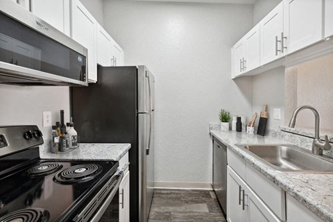 a kitchen with a stove refrigerator and sink