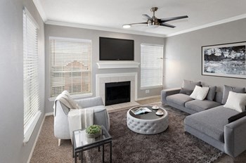 Model Living Room Large Windows Model living room carpet and 3 large windows with TV above fireplace in middle. - Photo Gallery 2