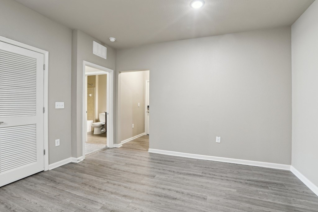Model living room with a wood-stlye floor and white walls.