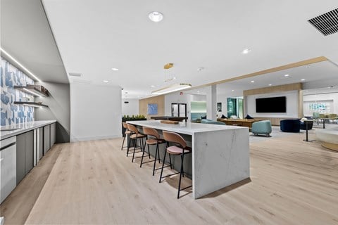A modern kitchen with a long table and chairs.