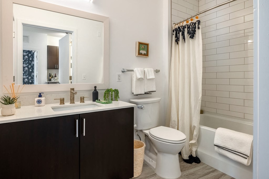 Model bathroom with a toilet and a sink and a mirror