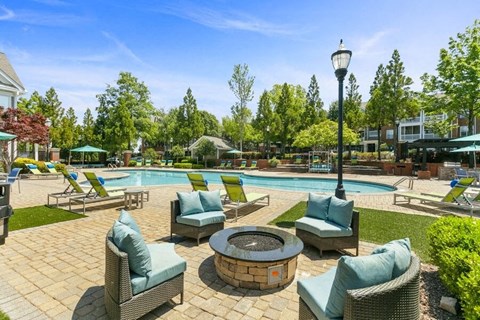 Two-Bedroom Luxury Apartments in Marietta, GA - Parkside at Town Center - Resort Style Pool Courtyard With Lounge Chairs, Shaded Seating, Fire Pit Gathering Area, And Landscaped Surroundings.