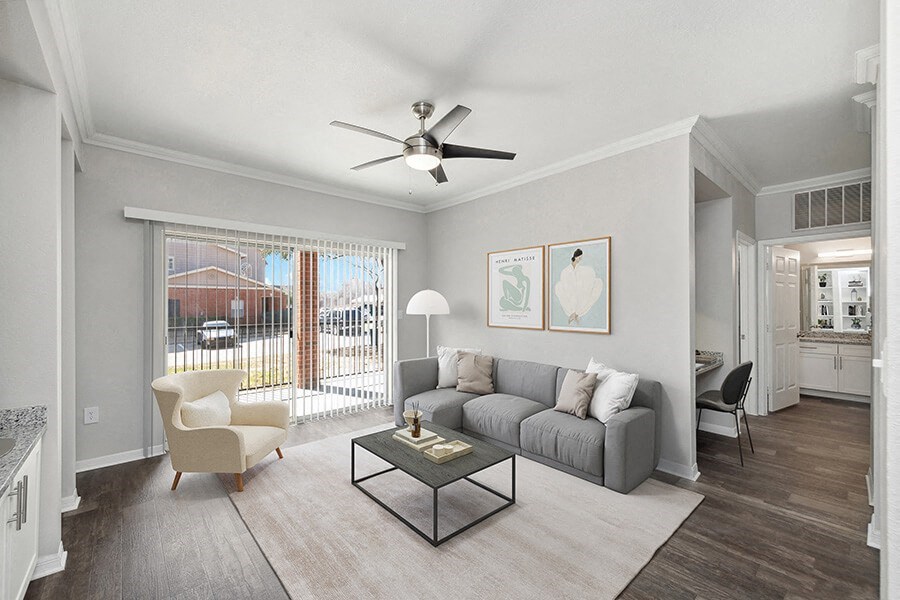 Model Living Room with Wood-Style Flooring and Patio Accessibility at Chapel Hill Apartments in Lewisville, TX.
