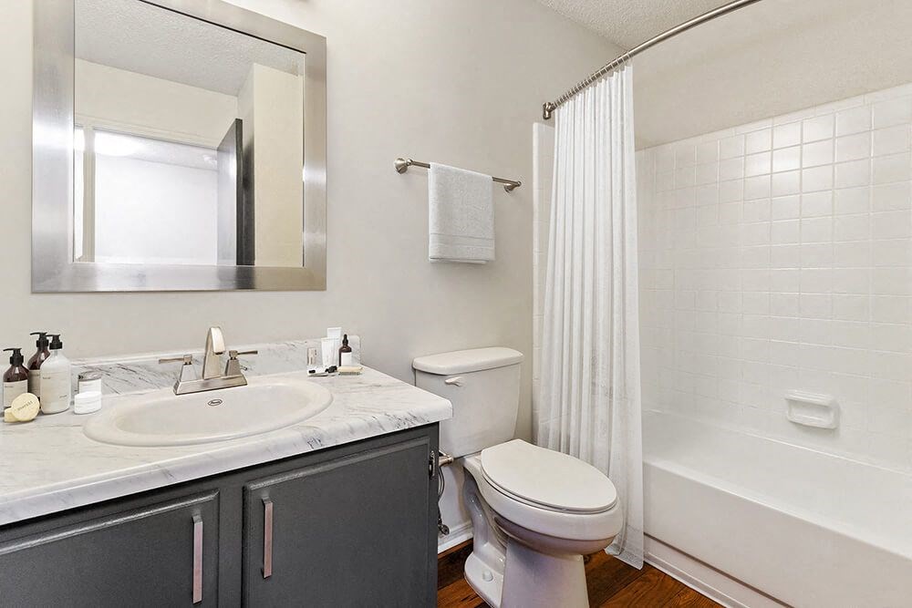 Model Bathroom with Wood-Style Flooring and Shower/Tub at Grandstand Apartments in Marietta, GA.
