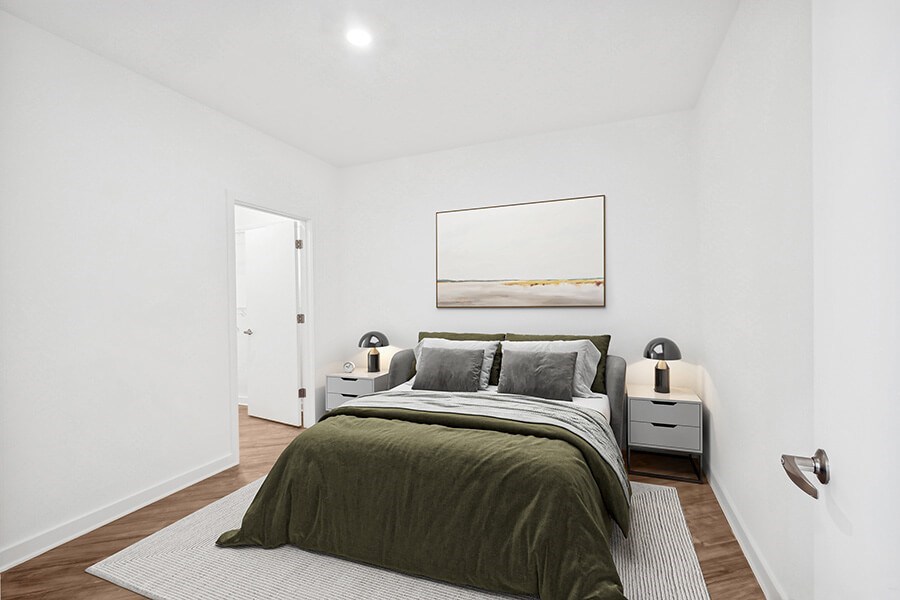 Model Bedroom with Wood-Style Flooring and attached Bathroom at Stella Apartments located in New Carrollton, MD.