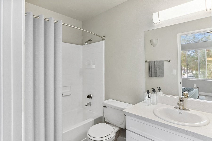 Model Bathroom with White Cabinets and Shower/Tub at Meadow Ridge Apartments in Las Vegas, NV.