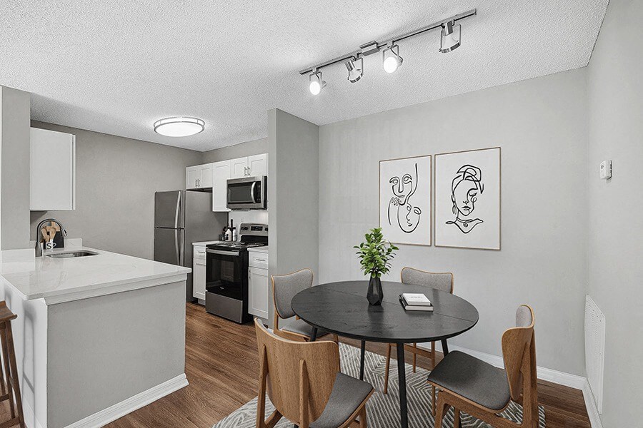 Model Dining Room and Kitchen Area with Wood-Style Flooring at Fountains Lee Vista Apartments in Orlando, FL.