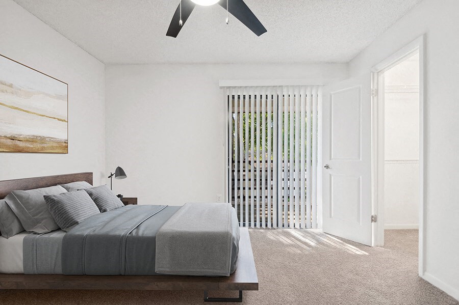 Model Bedroom with Carpet, Walk In Closet & Patio Accessibility at Rosehill Preserve Apartments located in Orlando, FL.