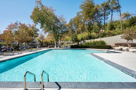 One-Bedroom Apartments in Sandy Springs, GA - Edgewater at Sandy Springs - Resort-Style Swimming Pool With Wide Sundeck, Lounge Chairs, And Tree-Lined Views Under The Sky.