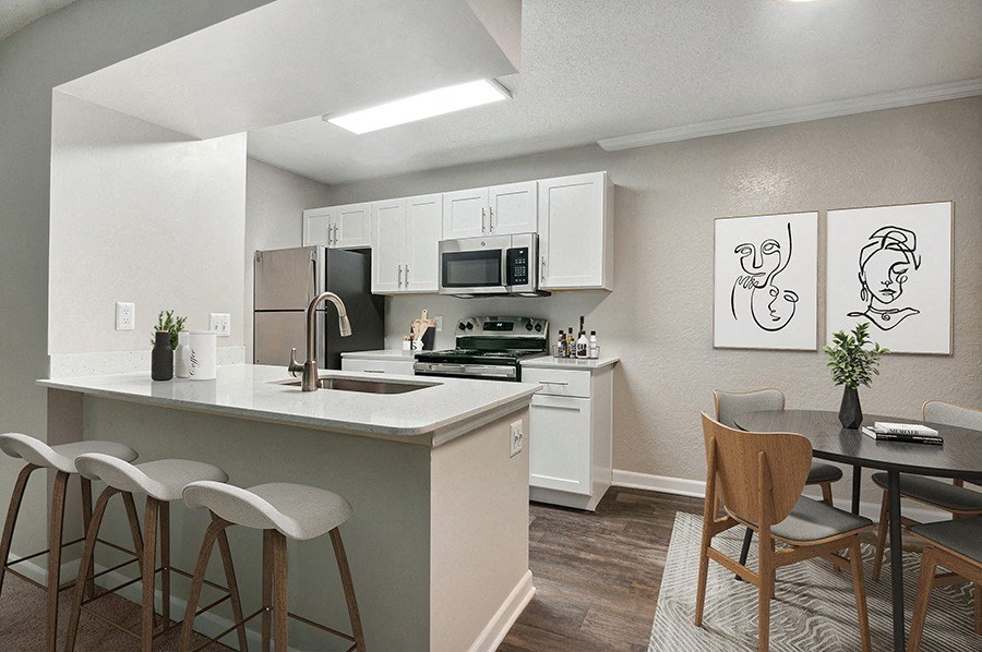Model Dining Room and Kitchen Area with Wood-Style Flooring at Arbor Village Apartments in Charlotte, NC.