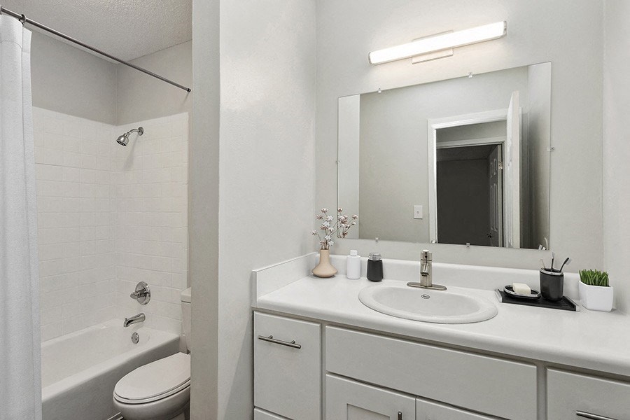Model Bathroom with White Cabinets, Wood-Style Flooring and Shower/Tub at Parc at Creekside Apartments in Kansas City, MO.