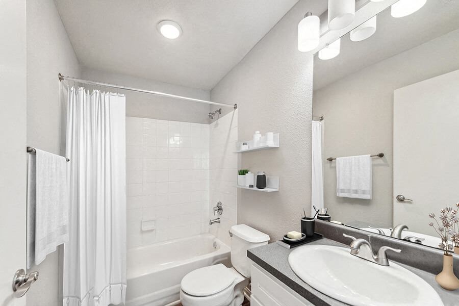 Model Bathroom with White Cabinets, Wood-Style Flooring and Shower/Tub at Lake Cameron Apartments located in Apex, NC.
