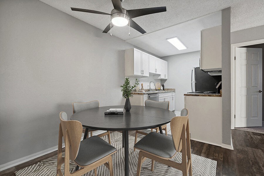 Model Dining Room with Wood-Style Flooring and View of Kitchen at Liberty Creek Apartments in Aurora, CO.