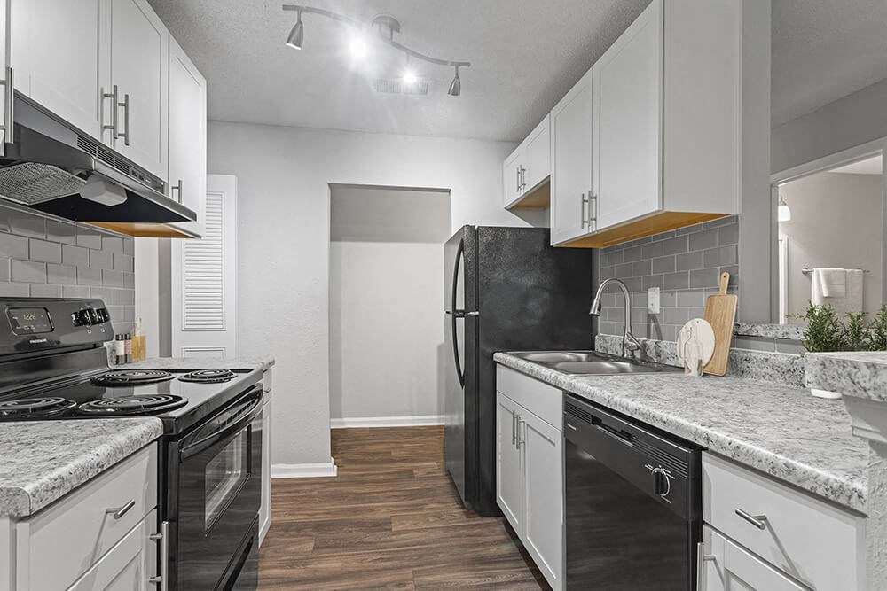 Model Kitchen with White Cabinets and Wood-Style Flooring at Corners at 1700 Apartments in Atlanta, GA.