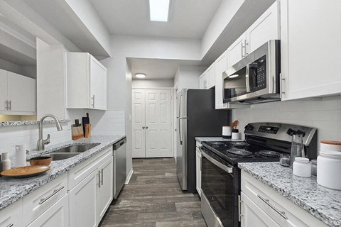 a kitchen with white cabinets and a black stove