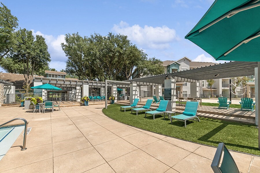 Community Swimming Pool with Pool Furniture at Essence Apartments in Dallas, TX.