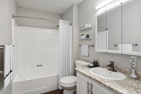 Model Bathroom with White Cabinets, Wood-Style Flooring and Shower/Tub at Overlook Point Apartments in Salt Lake City, UT.