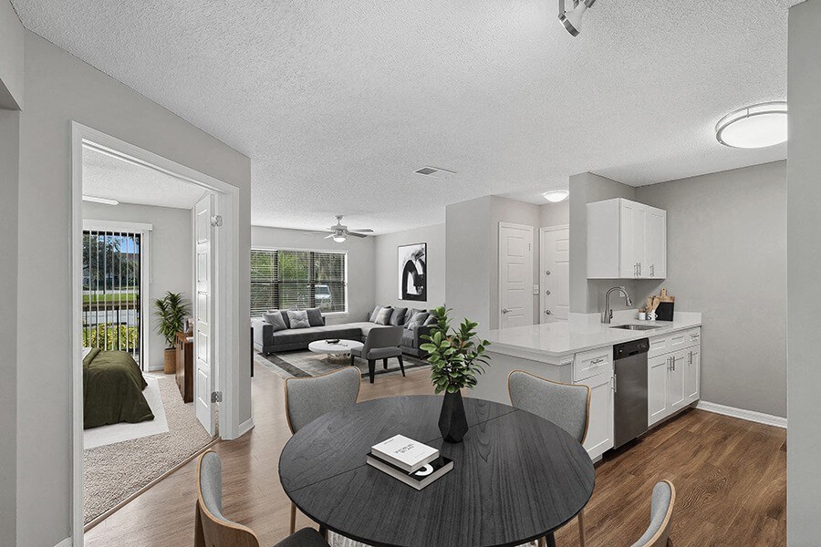 Model Living Room with Wood-Style Flooring and View of Kitchen and Living Room Area at Fountains Lee Vista Apartments in Orlando, FL.