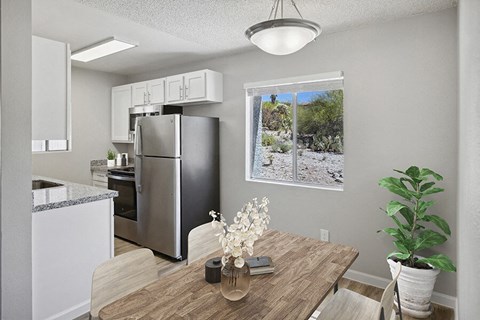 an open kitchen and dining room with a stainless steel refrigerator