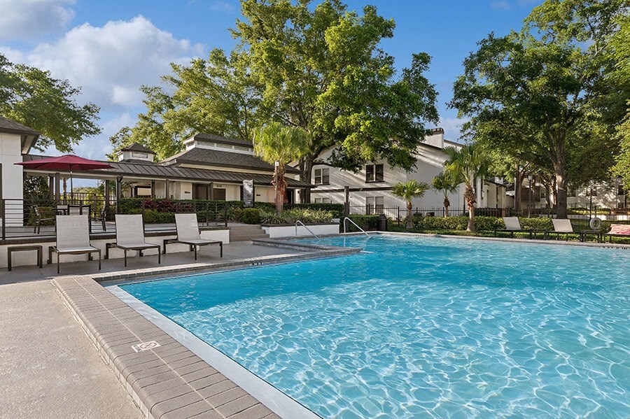 Community Swimming Pool with Pool Furniture at Rosehill Preserve Apartments located in Orlando, FL.
