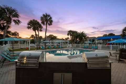 Outdoor BBQ Area with Furniture and Pool View at Park at 7200 Apartments in Jacksonville, FL.