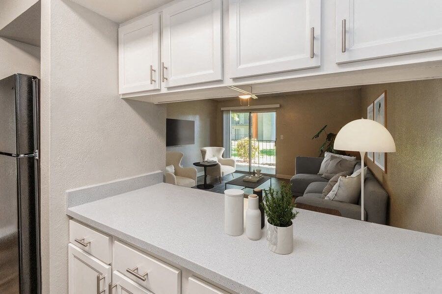 Model Kitchen with White Cabinets and Living Room View at Indigo Park Apartments in Albuquerque, NM.