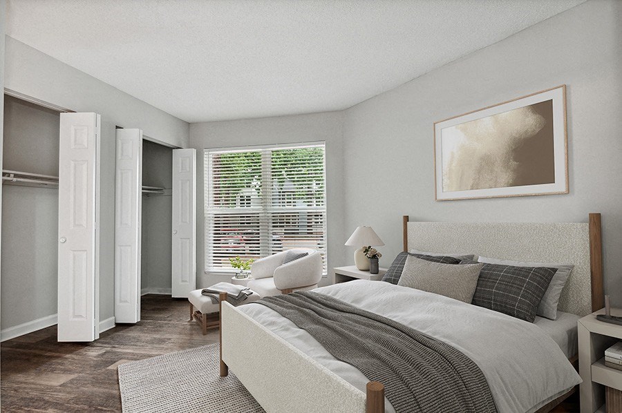 Model Bedroom with Double Closets and Wood-Style Flooring at Arbor Village Apartments in Charlotte, NC.