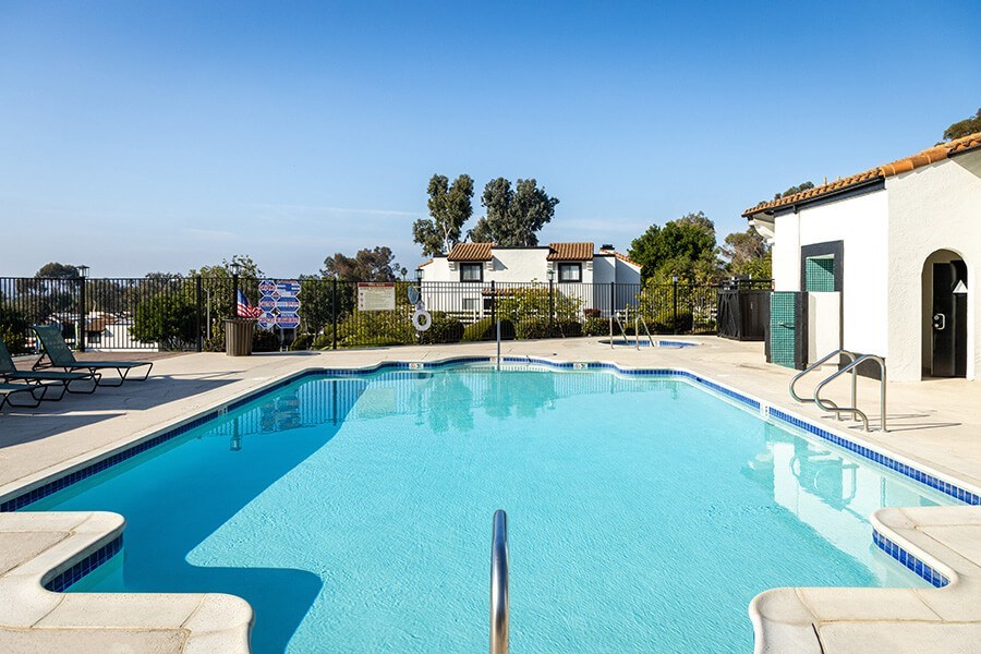 Community Swimming Pool with Pool Furniture at Santa Fe Ranch Apartments located in Carlsbad, CA.