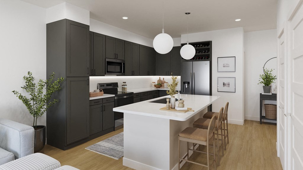 Model kitchen with dark cabinetry at The Howard Apartments in Manor, Texas
