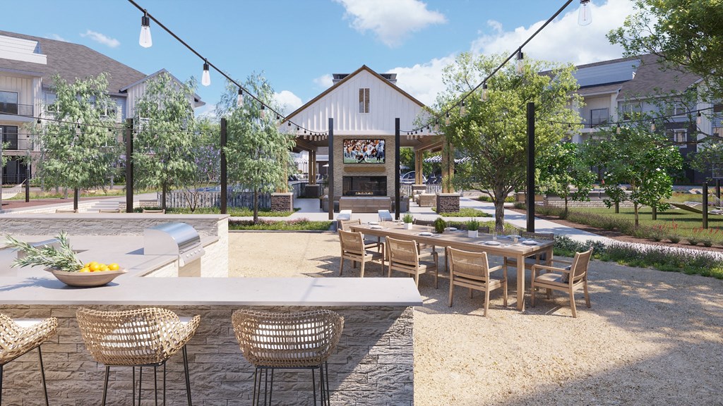 Outdoor kitchen with tables at The Howard Apartments in Manor, Texas