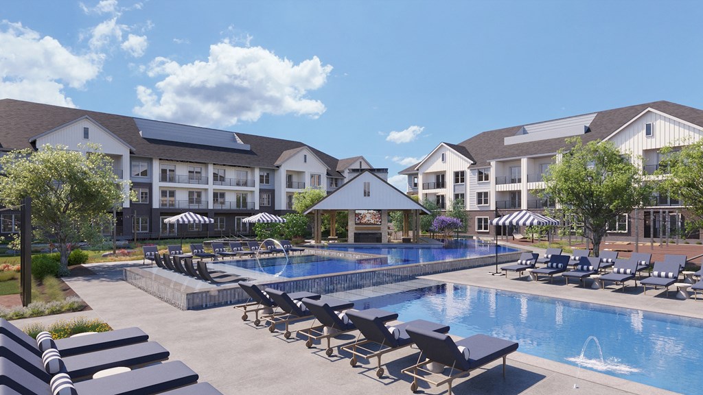 Pool and sundeck with loungers at The Howard Apartments in Manor, Texas